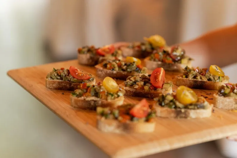 Bruschettas aux légumes grillés et tomates cerises sur planche en bois